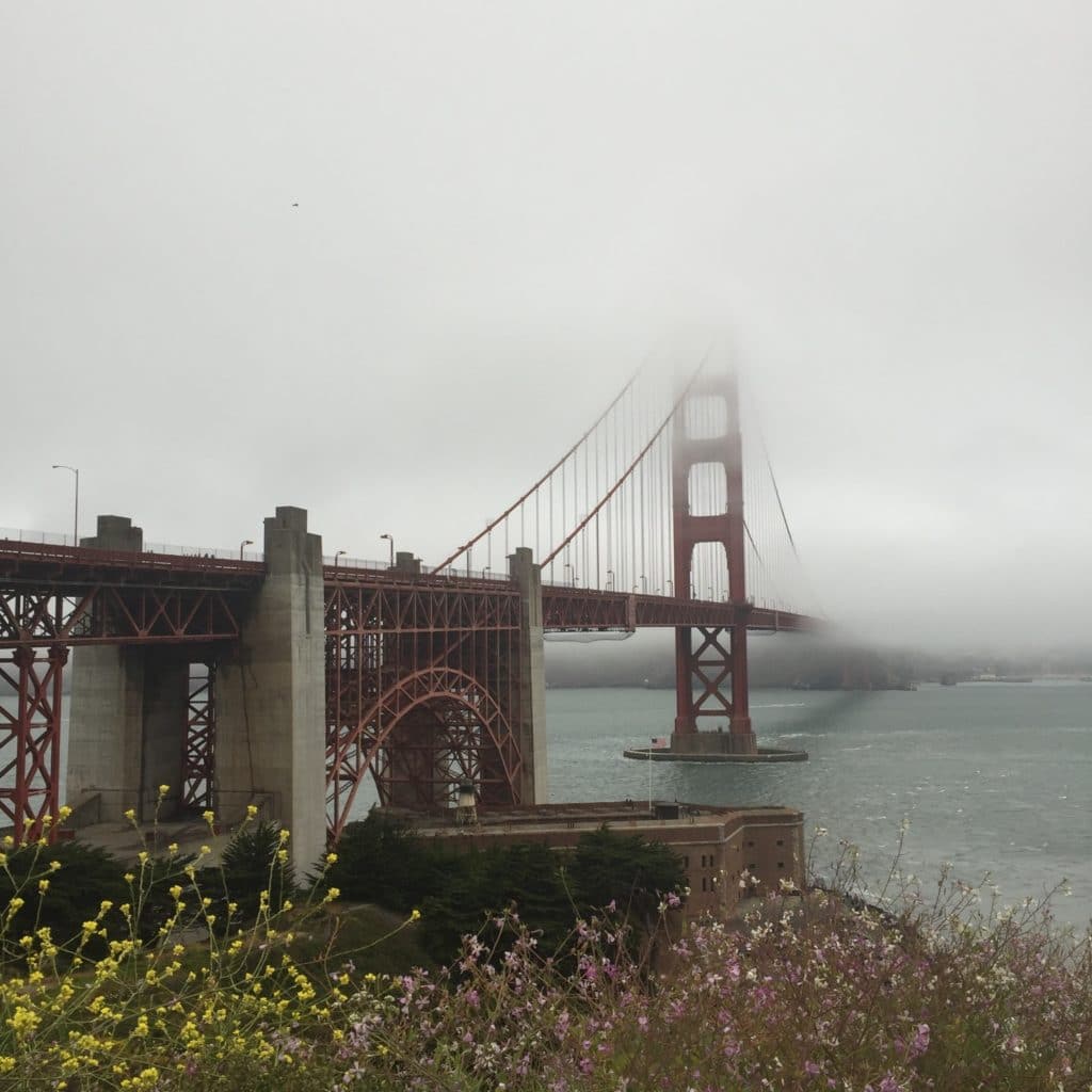 golden gate red bridge stretching into the fog