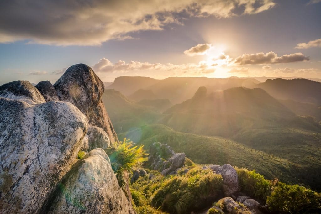 boulders against sunrise and mountain greenspace