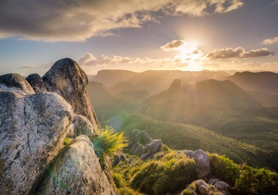 boulders against sunrise and mountain greenspace