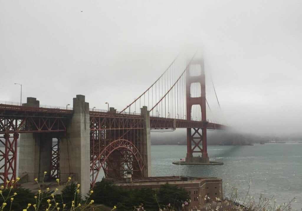 golden gate red bridge stretching into the fog